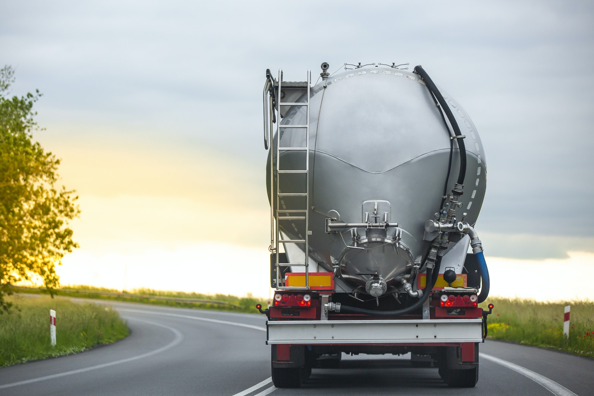 Long vehicle truck with tank trailer on a highway.